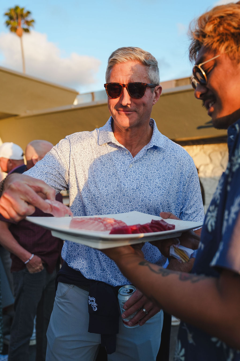 A chef holding a sashimi platter for the room